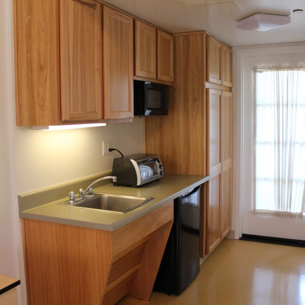 El Carrillo apartment kitchen with wood finish cabinets
