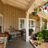 Outside shot of benches and chairs on the porch of the property