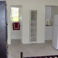 Inside a unit, view of a room with a fridge and cabinet