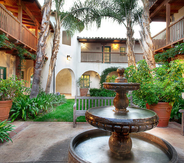 Outside shot of the courtyard with a water fountain and the units in the background