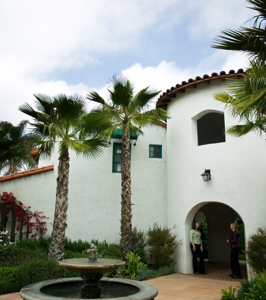 Outside view of two women standing at the entryway near the water fountain