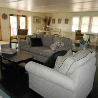 Inside of a common room with couches, tables, and chairs