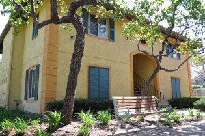 Outside view of the building including a bench and foliage