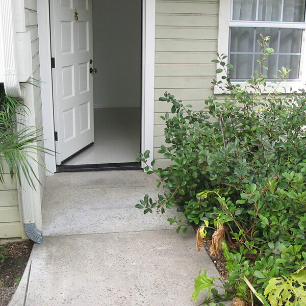 Outside view of the path leading to an open door of a unit