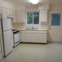 Inside a unit, view of the full kitchen and a door leading outside
