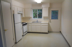 Inside a unit, view of the full kitchen and a door leading outside