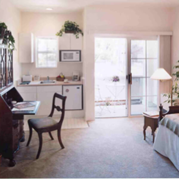 Inside a unit, showing the bedroom with a small desk and kitchenette