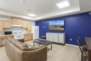 photo of community room with kitchen, tv, couch