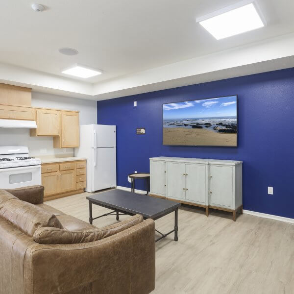 photo of community room with kitchen, tv, couch