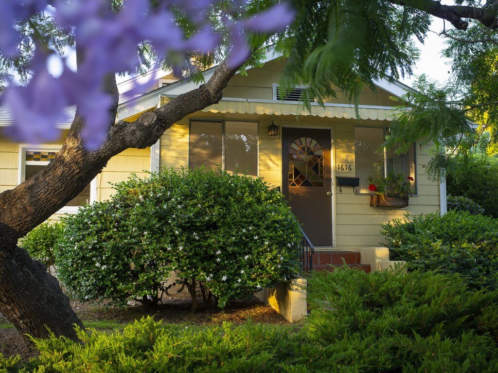 yellow house with tree in front